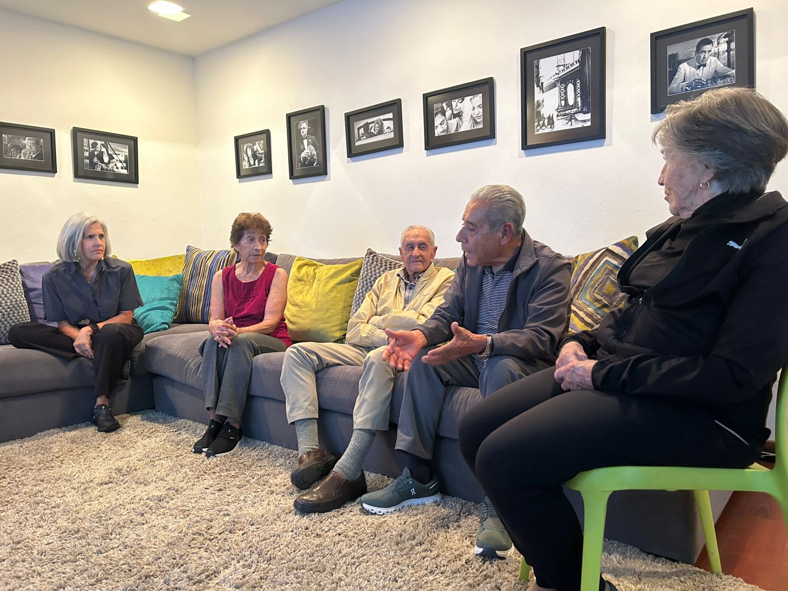 Grupo de personas conversando sentadas en un sillón durante una sesión de convivencia