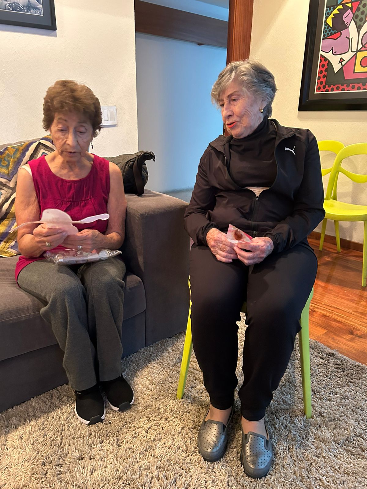 Dos participantes sentadas revisando el material de una actividad